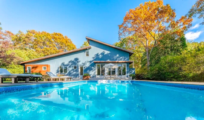 Best Airbnbs in the Hamptons - A bright pool in the backyard of an asymmetrical roofed house.
