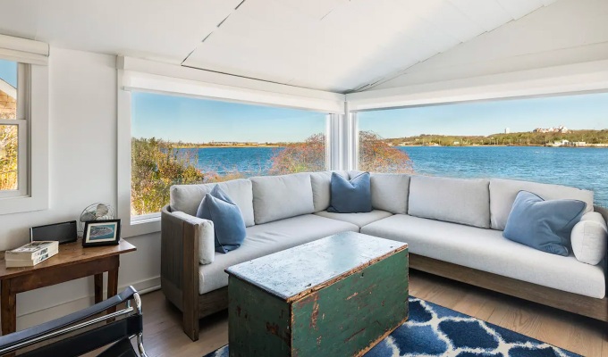 Best Airbnbs in the Hamptons - A bright living room in a Hamptons home with large windows that looks out onto the ocean.