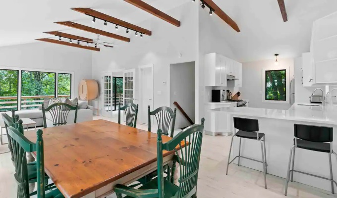 Best Airbnbs in the Hamptons - A modern, yet classic kitchen/dining room of a Hamptons home. It has high ceilings with exposed beams.