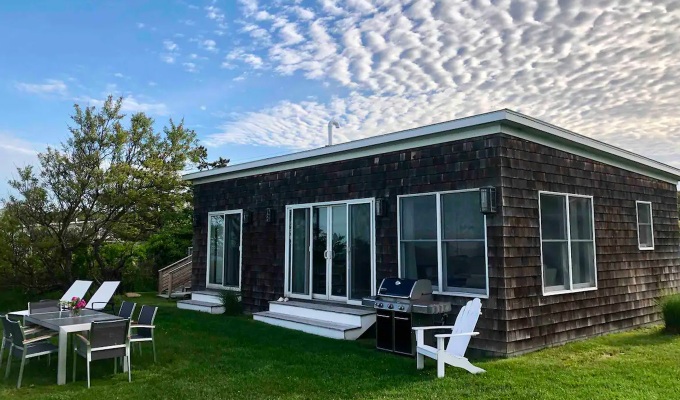 Best Airbnbs in the Hamptons - A small beach weathered cottage in the Hamptons with patio furniture in the backyard.