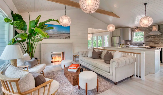 Best Airbnbs in the Hamptons - A cozy living room with modern furniture and lighting, medium ceilings and a fire place.
