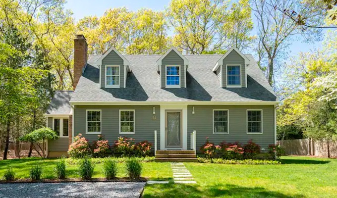 Best Airbnbs in the Hamptons - A large colonial home with a big front lawn surrounded by trees.