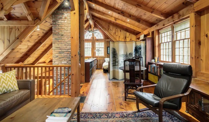 Best Airbnbs in the Hamptons - The cozy cabin-like living room of a Hamptons home. It's got tall ceilings and cabin-esque furinture.