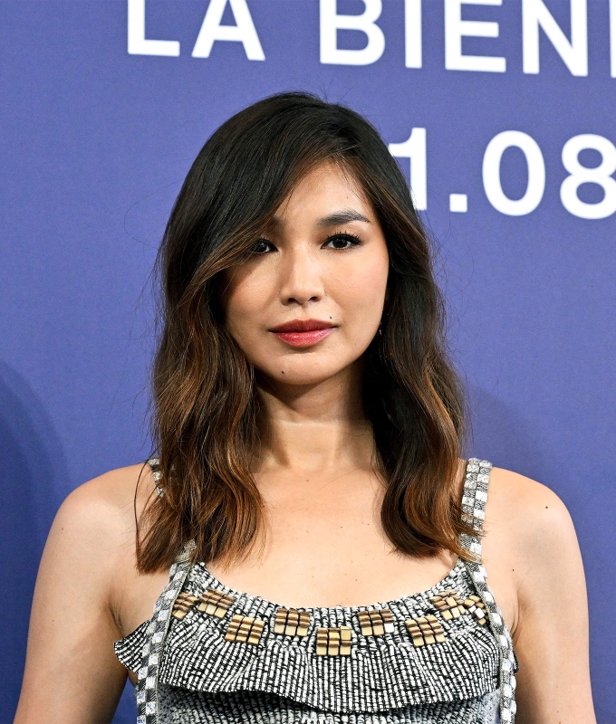 haircuts for oval faces: gemma chan wears a below-the-shoulder cut with loose waves