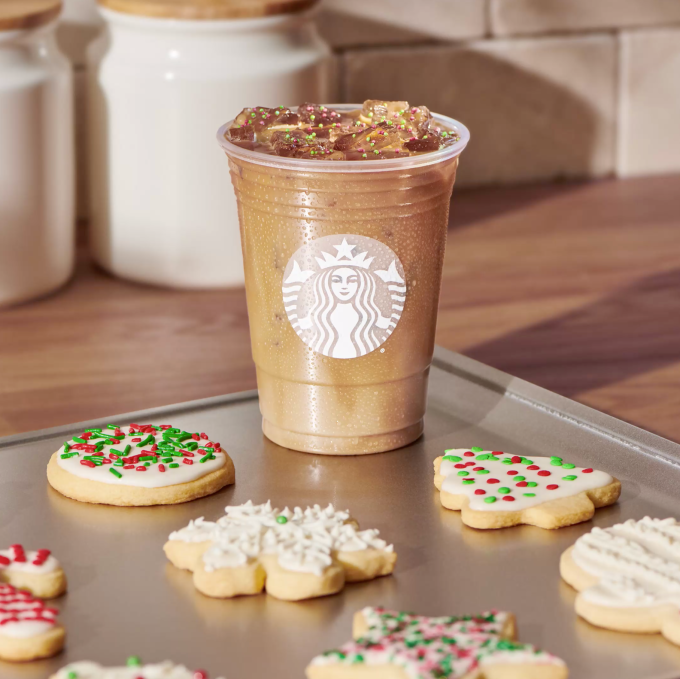 vegan at starbucks: Sugar Cookie Almondmilk Latte on a sheet pan with holiday sugar cookies